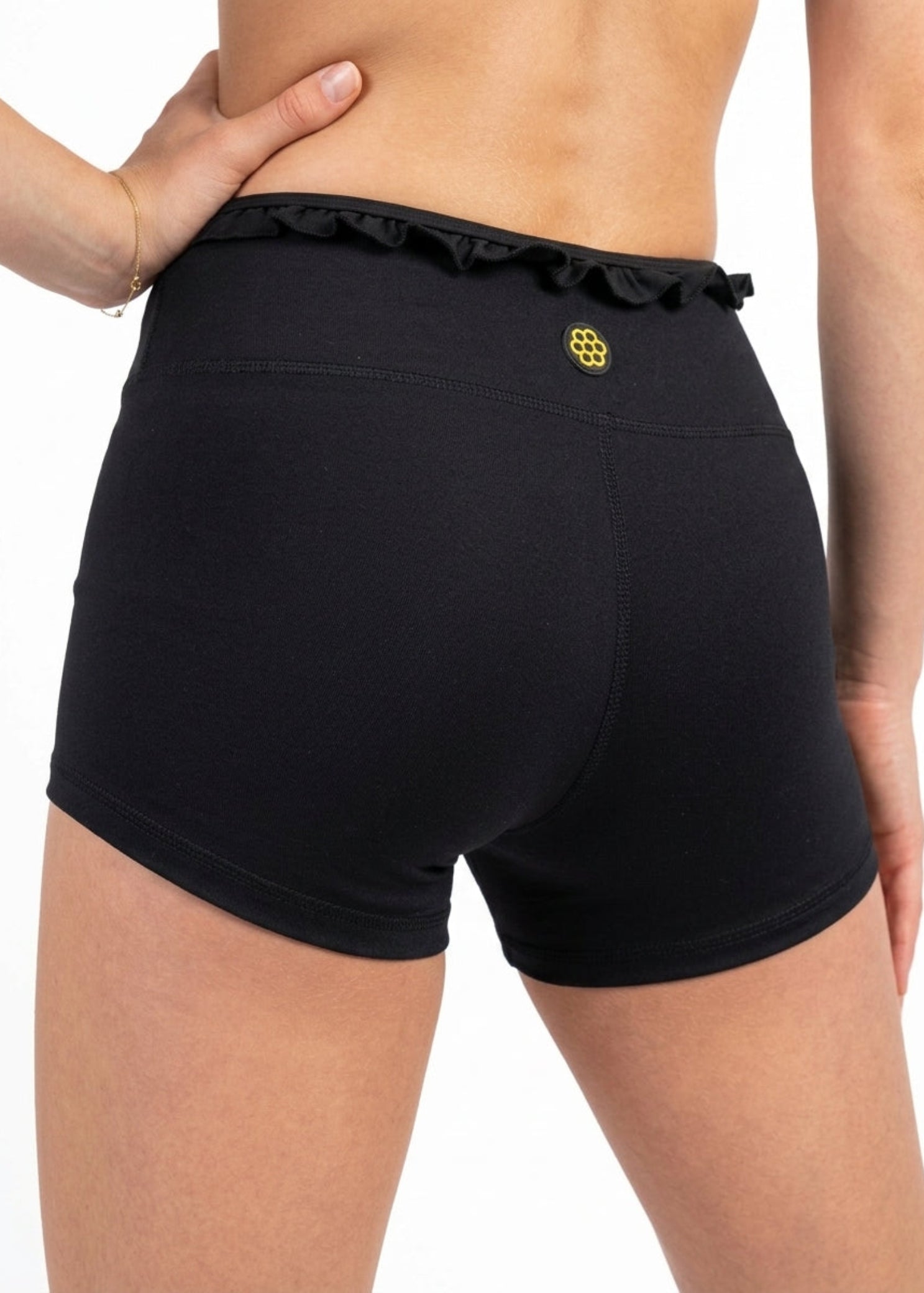 Honeycut Cabana Short in Black, back view showing nylon-spandex fabric, ruffled waistband and logo