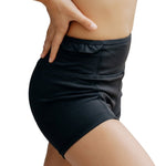 Honeycut Cabana Short in Black, side view showing nylon-spandex fabric, fitted silhouette and ruffled waist