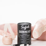 Suffolk Darning Sewing Kit in Pink, lifestyle view showing cotton thread, cutter and thimble beside pointe shoes