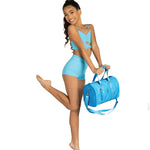 Danznmotion Jr Dance Duffel in Turquoise, lifestyle view showing front zip pocket, heart emblem, and logo badge