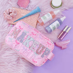 OMG Accessories Makeup Bow Pouch in Pink, lifestyle view showing quilted bow-print exterior and zip closure