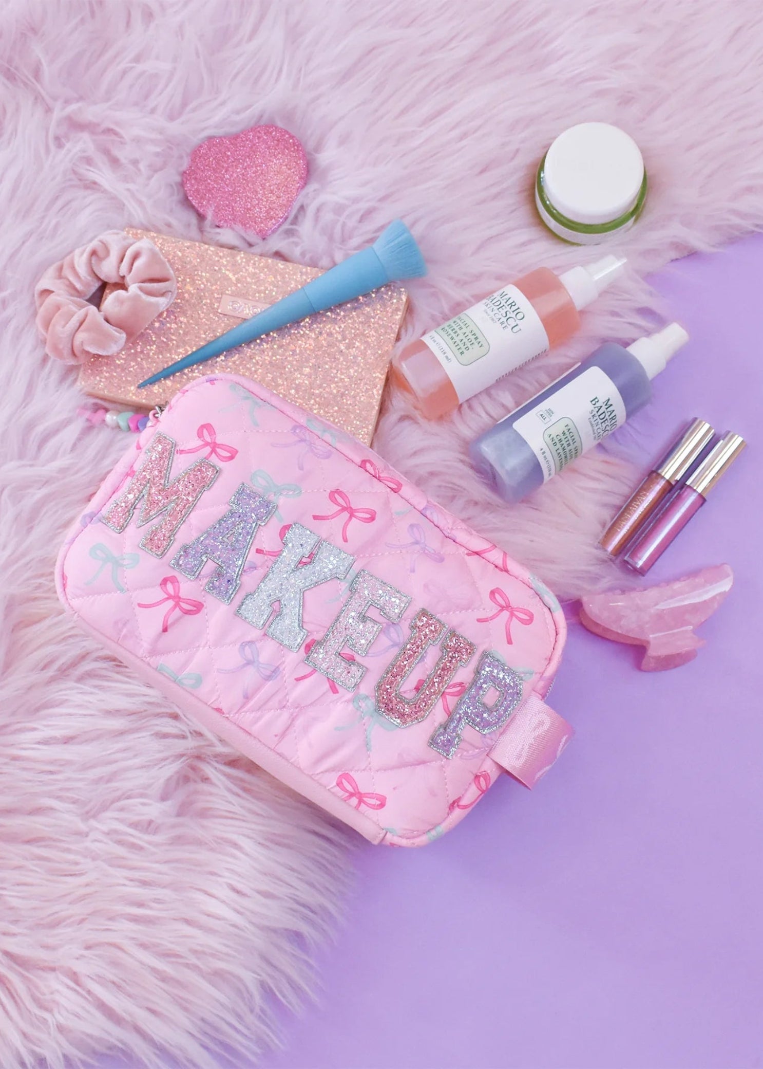 OMG Accessories Makeup Bow Pouch in Pink, lifestyle view showing quilted bow-print exterior and zip closure