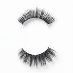 C&J Merchantile Plain Eyelashes, unboxed view showing human hair lash pair with curved bands and layered fibers