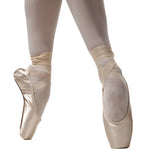 R Class Pristine Pointe Shoe in Pink, lifestyle view showing satin upper with ribbons tied en pointe