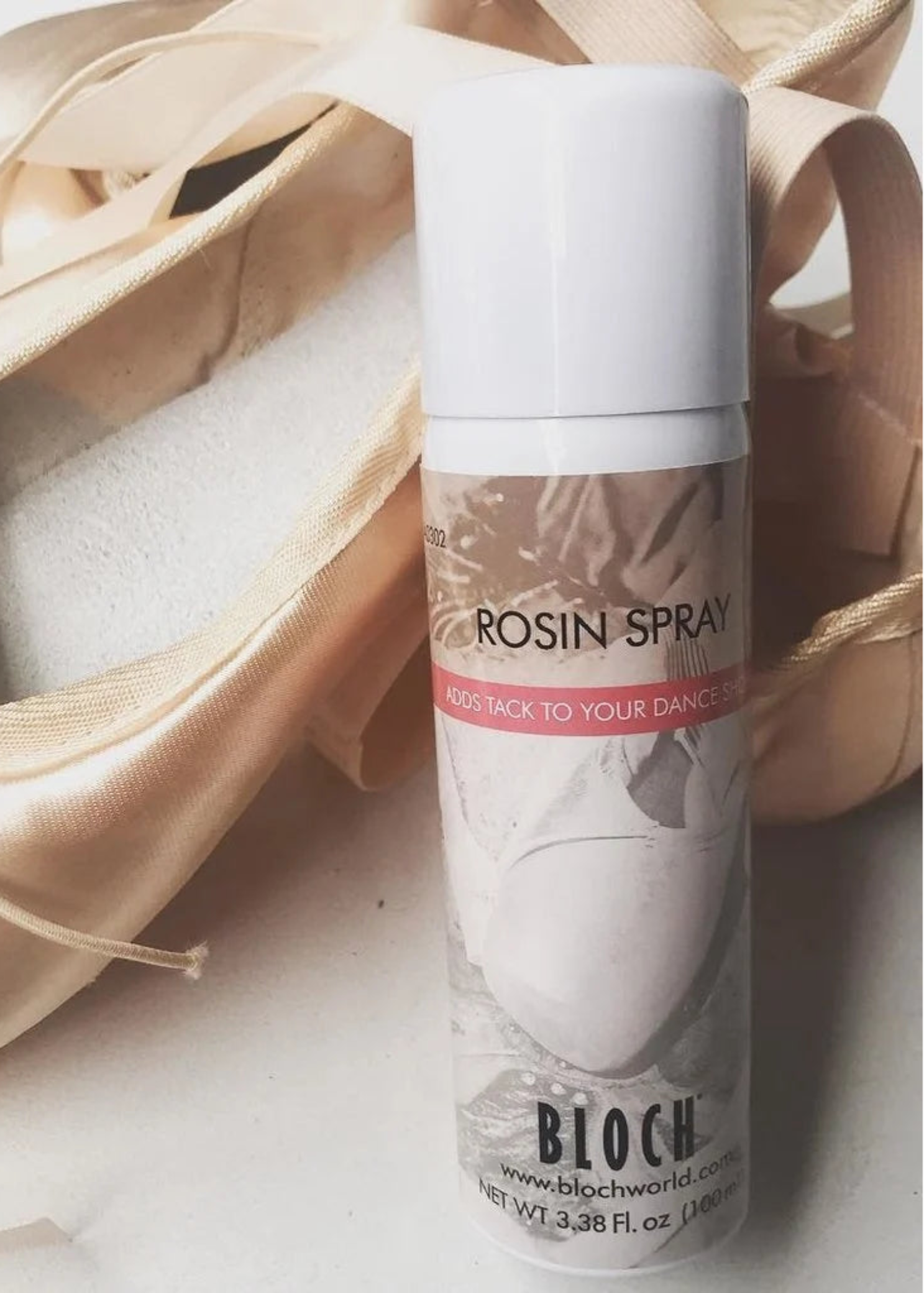 Bloch Rosin Spray, detail view showing labeled 100ml aerosol can with white cap beside pointe shoes