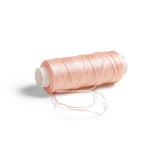 RP Collection Sewing Thread in Pink, detail view showing wax-coated thread and loose strand