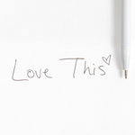 Pippi Post Slippers & Bow Gel Pen, close up view showing writing tip and black gel ink spelling Love This