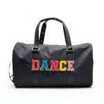 Dasha Designs Multi Dance Duffel in black, front view showing multi-color chenille DANCE lettering, dual handles, and gold hardware