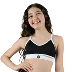 Young girl wearing a black sports bra and shorts set on a white background