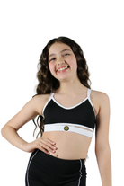 Young girl wearing a black sports bra and shorts set on a white background